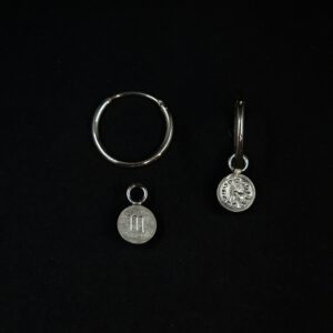 Rückseite von handgefertigten Silbercreolen mit Einhängern. Auf dem einen ist ein Sternzeichensymbol auf dem anderen eine Uhr