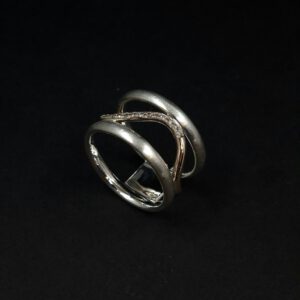 Handgearbeiteter, eleganter Ring aus Silber und Gold in geschwungenem Design mit Brillanten ausgefasst.