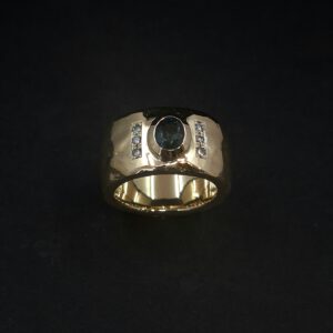 Handgearbeiteter Goldring mit blauem Kundendiamant und sechs weißen Brillanten.