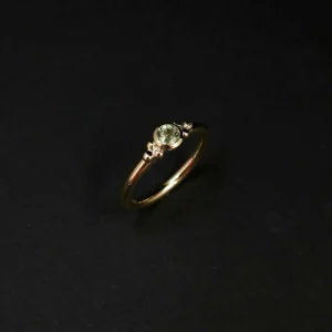 Handgefertigter Goldring mit grünem Saphir und sechs kleinen Goldkügelchen neben dem Stein